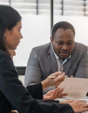 Multiracial diverse businesspeople brainstorm work together on paperwork at team meeting in office. Concentrated multiethnic colleagues discuss business ideas. Teamwork concept Multiracial diverse businesspeople brainstorm work together on paperwork at team meeting in office. Concentrated multiethnic colleagues discuss business ideas. Teamwork concept.